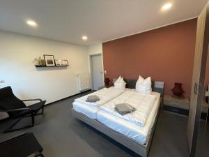ein Schlafzimmer mit einem großen Bett und einem Stuhl in der Unterkunft Ferienhaus für 6 Personen ca 108 m in Plauen, Sachsen Vogtland in Plauen + 14 Fotos