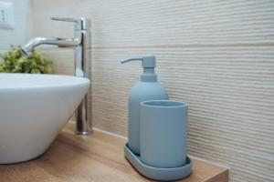 a bottle of soap is sitting next to a sink at Next stop Ostia in Lido di Ostia