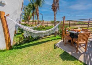 - un hamac dans l'arrière-cour avec une table et des chaises dans l'établissement Loft na praia em Resort 5 estrelas, à Trairi