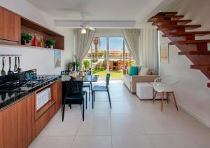 une cuisine et un salon avec une table et des chaises dans l'établissement Loft na praia em Resort 5 estrelas, à Trairi