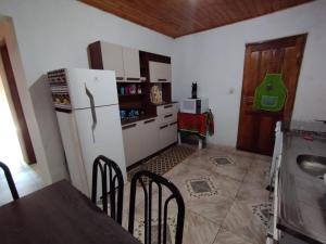 Una cocina con refrigerador y una mesa y sillas. en Casa Vista Verde, en Camanducaia 6 fotos más