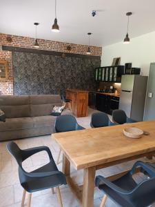 a living room with a wooden table and chairs at domaine des étangs du bois de l'abbaye in Rejet-de-Beaulieu +19 photos