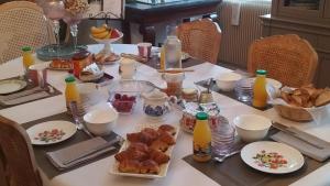 a table with breakfast food and bottles of orange juice at La maison des Roses in Saint-Jodard