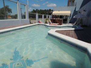una gran piscina al lado de una casa en Suites Mirage en Pinamar