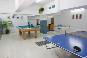 Habitación con mesa de ping pong y pelota de ping pong. en Suites Mirage en Pinamar