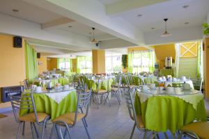 un salón de banquetes con mesas y sillas con manteles verdes en Suites Mirage en Pinamar