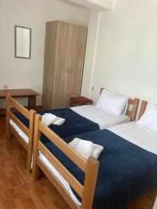 una habitación de hotel con dos camas y una mesa en Guest House Garden, en Budva