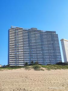 a large building on the beach next to a sandy beach at Stella Maris 55 in Amanzimtoti