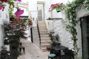 an alley with flowers and stairs in an alley with stools at Dimora il Capitello in Cisternino