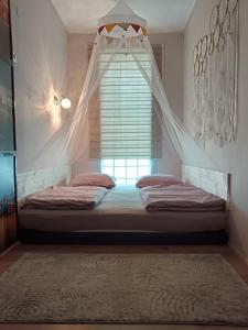 a bedroom with two beds and a window with curtains at Apartman ClaRa in Štúrovo