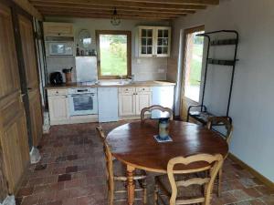 a kitchen with a wooden table and chairs at Tonneau normand insolite in Le Mesnil-Germain
