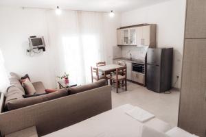 a living room with a couch and a kitchen at Villa Melodia Xhek in Ksamil