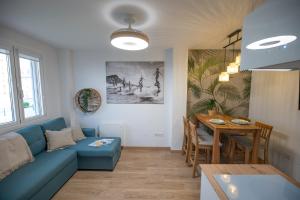 a living room with a blue couch and a table at El Escondite de Somo in Somo