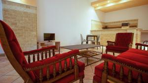 a living room with red chairs and a table at Mistral Guesthouse in Castro di Lecce