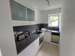 a kitchen with white cabinets and a black counter top at Claar Ferienwohnung Lindau Bodensee in Lindau