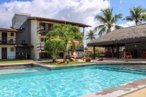 a swimming pool in front of a building at Pousada dos Hibiscus in Ilhéus