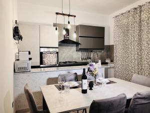 a kitchen with a table with wine bottles and chairs at La Bella Sicilia Suite in Floridia