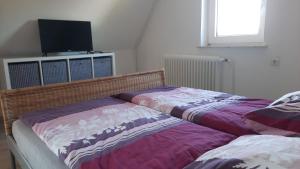 two beds sitting next to each other in a bedroom at Ferienwohnung Mittelpunkt in Schortens