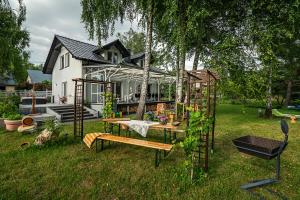 a house with a greenhouse and a bench in the yard at Villa Marta in Trzebinia