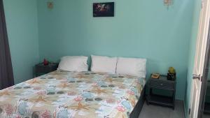 a bedroom with a bed with a colorful comforter at Sand Dollar Apartment B11 Serenity By The Sea in Kralendijk