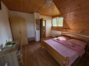 a bedroom with a large bed and a wooden ceiling at Apartman Majetić in Seliste Dreznicko