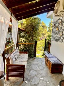 a porch with two chairs and a couch on a balcony at Villa Christina in Vourvourou +53 photos