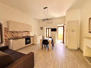 a living room with a table and a kitchen at Casa Lorenza a 300 m dalla spiaggia Rena Bianca in Santa Teresa Gallura