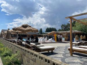 a group of chairs and umbrellas on a patio at Raduga Issyk kul - Радуга Иссык куль in Chon-Sary-Oy