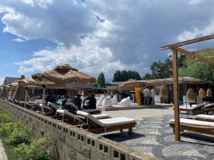 a group of people sitting on lounge chairs under an umbrella at Raduga Issyk kul - Радуга Иссык куль in Chon-Sary-Oy