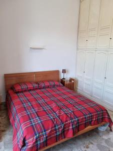 a bedroom with a bed with a red plaid blanket at viola in Sansepolcro