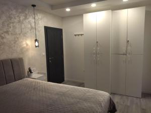 a bedroom with a bed and white cabinets and a bathroom at Apartment Miranda in Brela