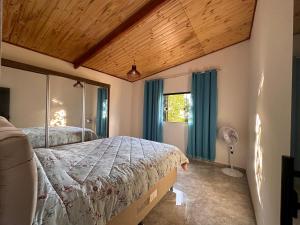 a bedroom with a bed and a window at Casa Pôr do Sol in Baependi