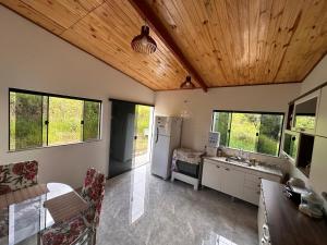 a kitchen with wooden ceilings and a table and chairs at Casa Pôr do Sol in Baependi
