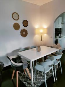 a dining room with a white table and chairs at Maison proche de Paris in Le Blanc-Mesnil