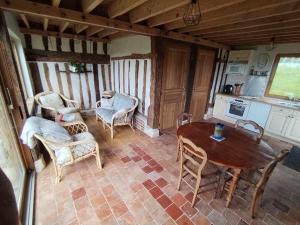 Una habitación con una mesa y sillas y una cocina. en Tonneaux normands insolites, en Le Mesnil-Germain 6 fotos más