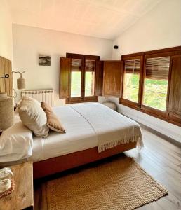 a bedroom with a large bed with wooden cabinets and windows at La Lolita ( Adults Only ) in Sant Mart&iacute; Vell