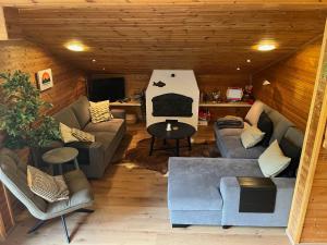 a living room with couches and chairs in a cabin at Alpendomizil Apfel in Mühlbach am Hochkönig