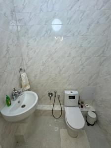 ein weißes Badezimmer mit Toilette und Waschbecken in der Unterkunft Трехкомнатные бизнес апартаменты в ЖК Заман in Atyrau