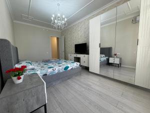 ein Schlafzimmer mit einem Bett und einem großen Spiegel in der Unterkunft Трехкомнатные бизнес апартаменты в ЖК Заман in Atyrau