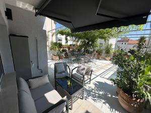 a patio with a couch and chairs and plants at Luxury Apartment Lu in Split
