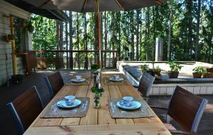 a wooden table with chairs and an umbrella on a patio at Aamuranta in Turku
