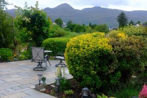 a garden with a table and some bushes at Ardenlea in Kyle of Lochalsh