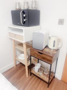 a microwave sitting on top of a table next to a counter at Cozy haven in Acrefair +5 photos
