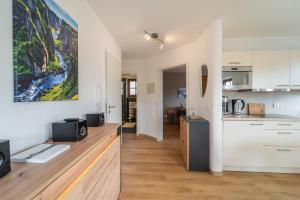 a kitchen and living room with a large painting on the wall at Am Sonneneck - DreiGipfelblick Fewo6 mit Sauna in Ruhpolding +14 photos
