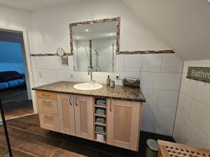 a bathroom with a sink and a mirror at Strandhaus am See in Kalkar
