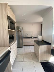 a kitchen with a stainless steel refrigerator and cabinets at Apto no Centro próximo a UFN - Garagem in Santa Maria +1 photo