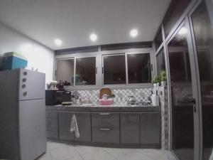 a kitchen with a white refrigerator and a sink at Marjane house in El Jadida
