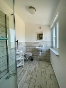 a bathroom with a toilet and a sink at Pokoje i domki letniskowe BROS in Dziwnów +55 photos