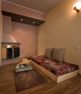 ein Wohnzimmer mit einem Bett und einem Kamin in der Unterkunft Livadi Suites in Arachova
