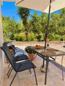 Un patio con una mesa y sillas y una sombrilla. en Riverside apartments, en Lefkada 7 fotos más